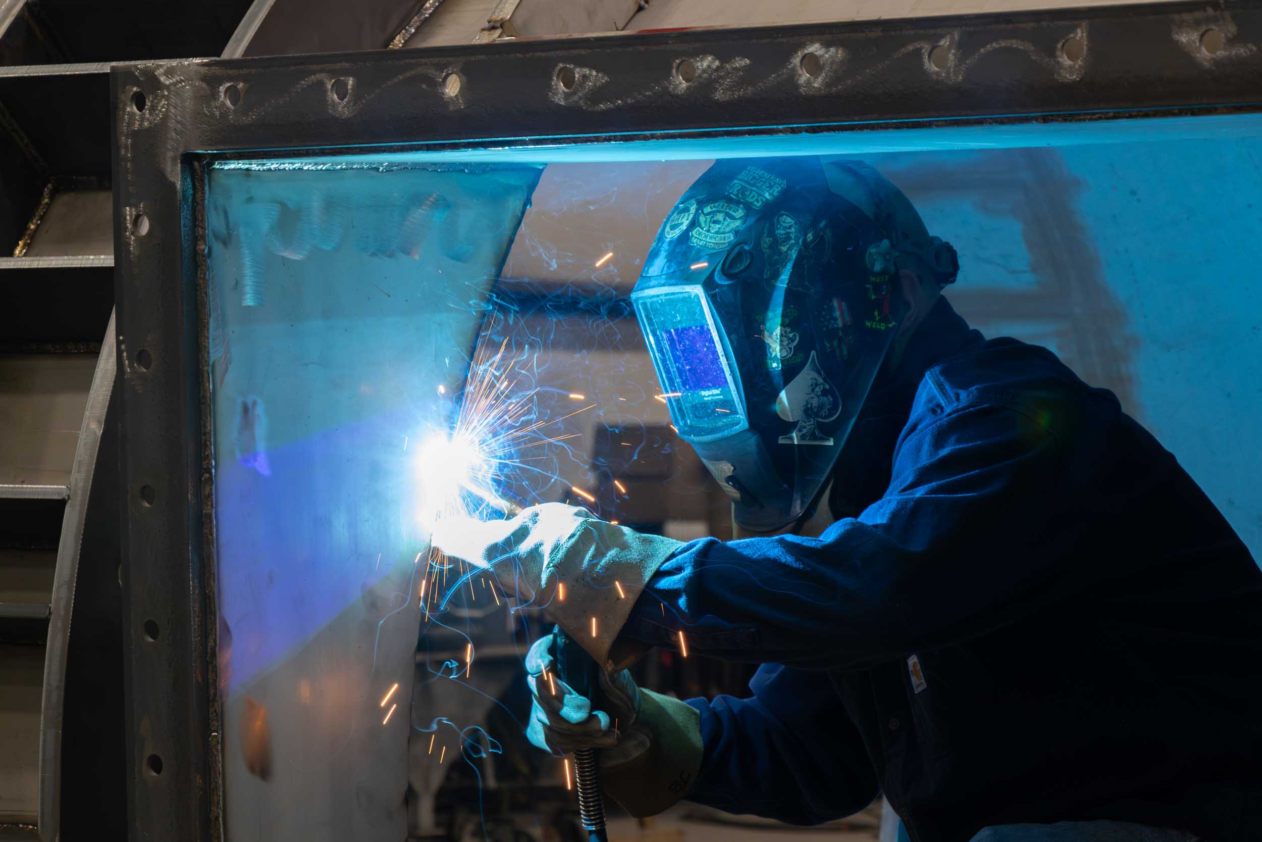 Welder working with protective helmet and sparks flying