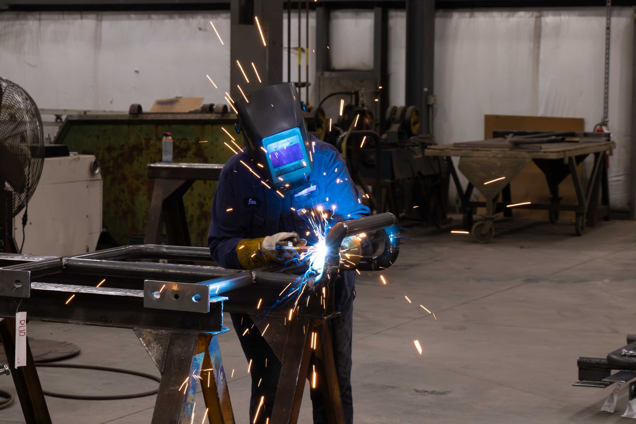 Welder working with metal in industrial workshop