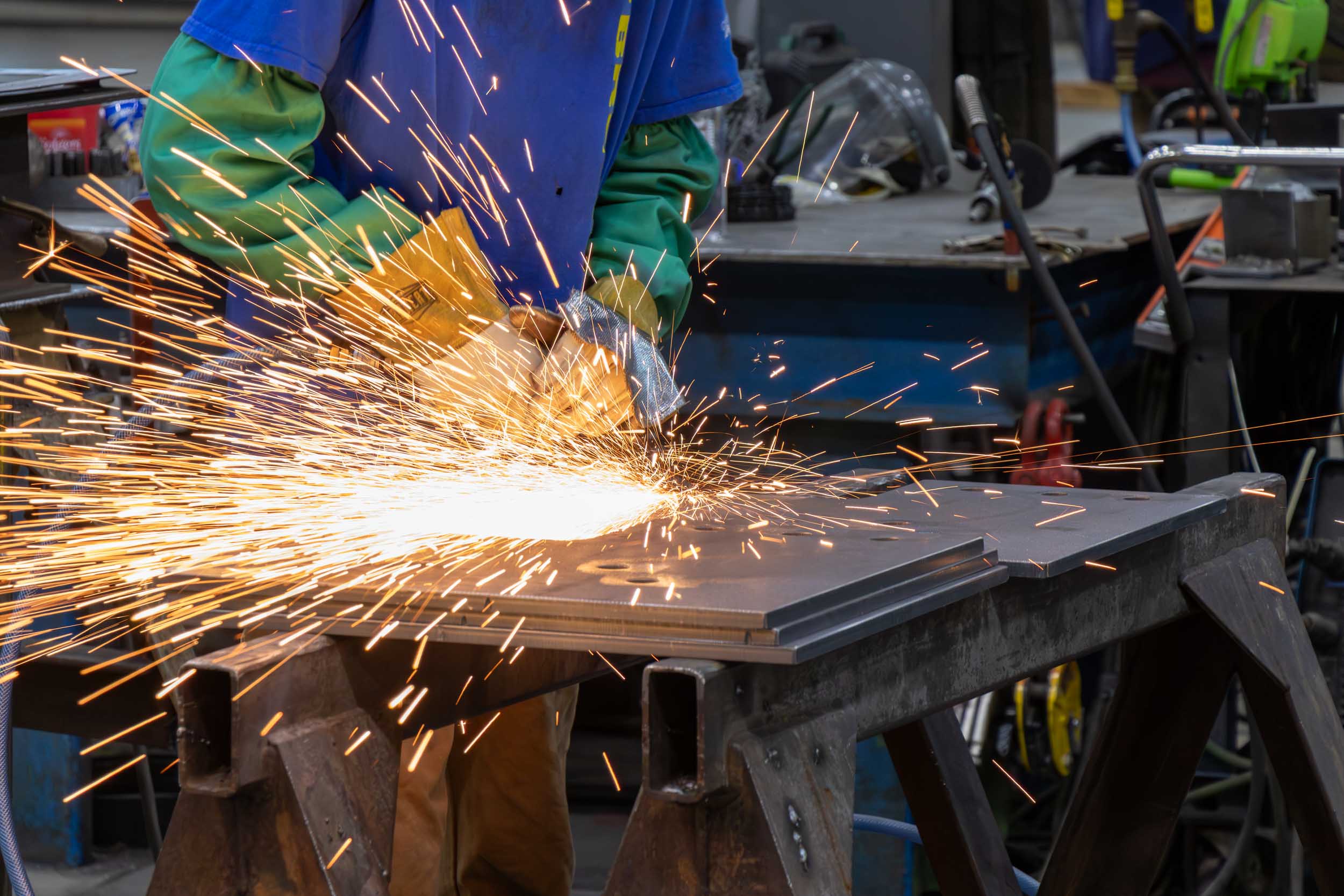 Worker grinding metal with sparks flying