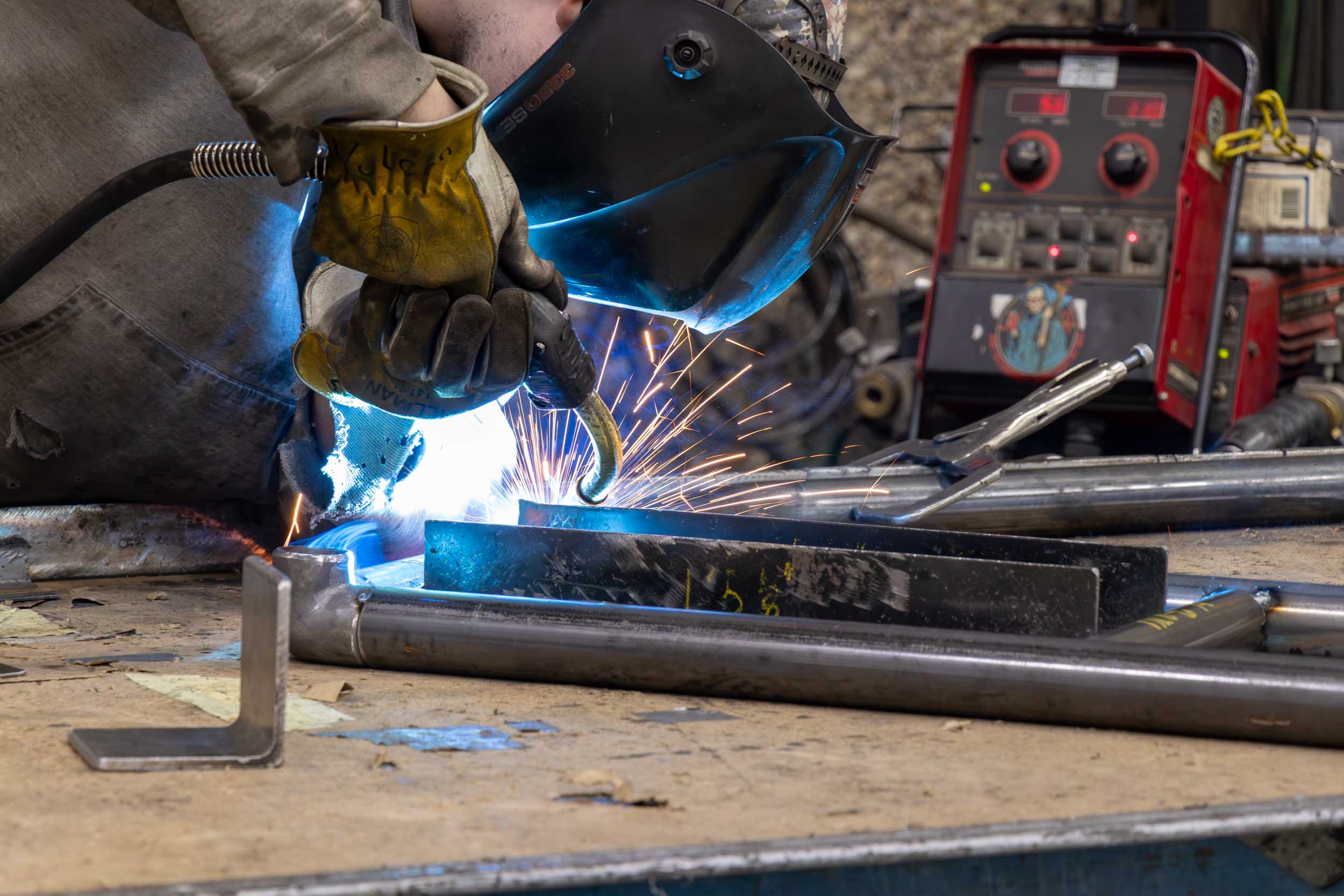 Worker welding metal parts with protective gear